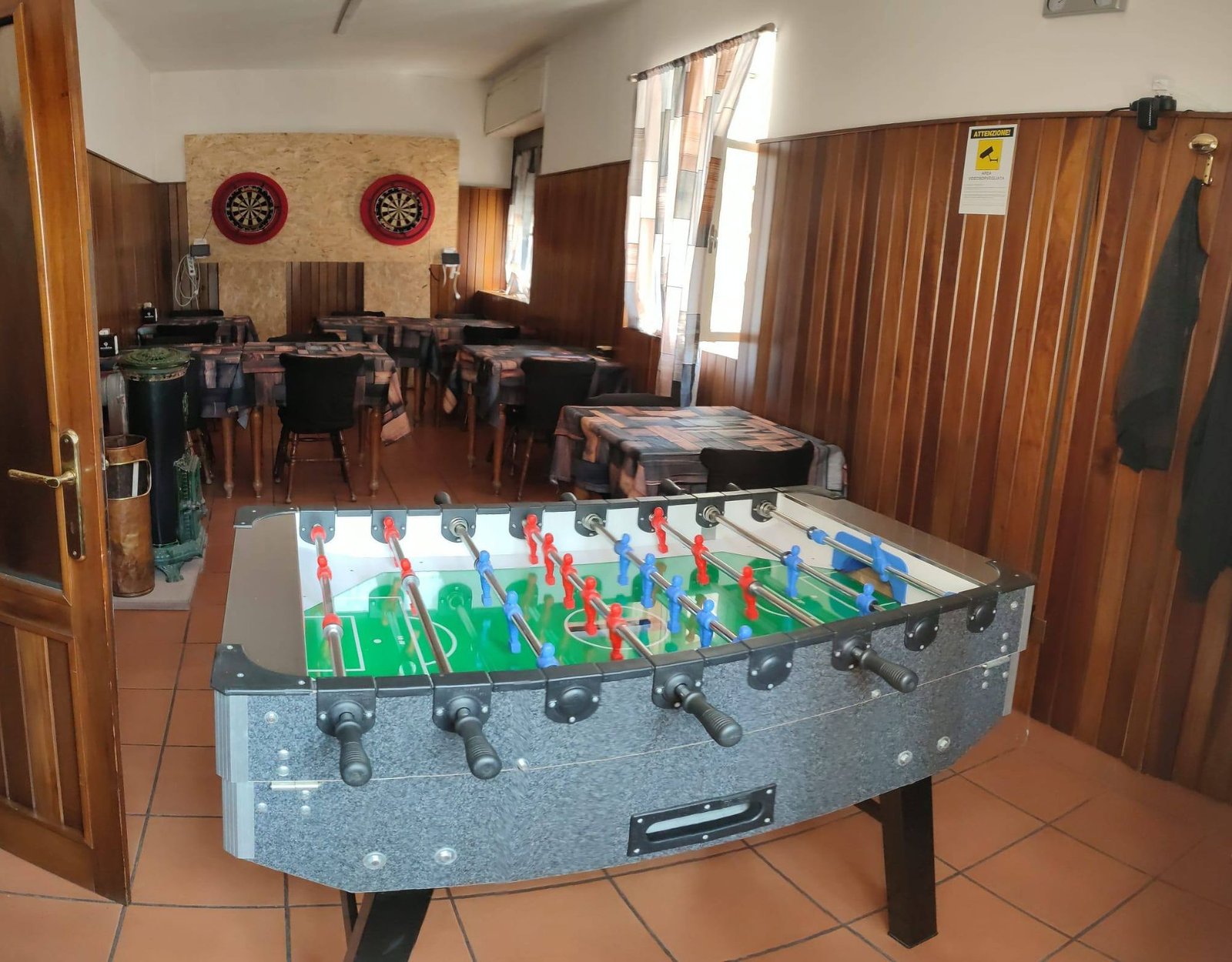 La saletta separata del Bar Buffet al Gatto Nero, con il calcio balilla e i tavoli apparecchiati